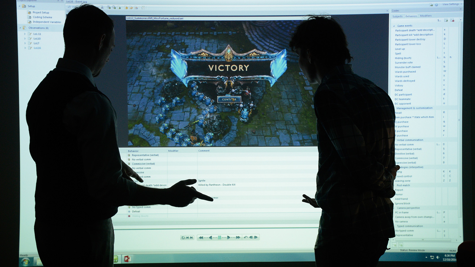 Two men looking at the League of Legends 'Victory' screen